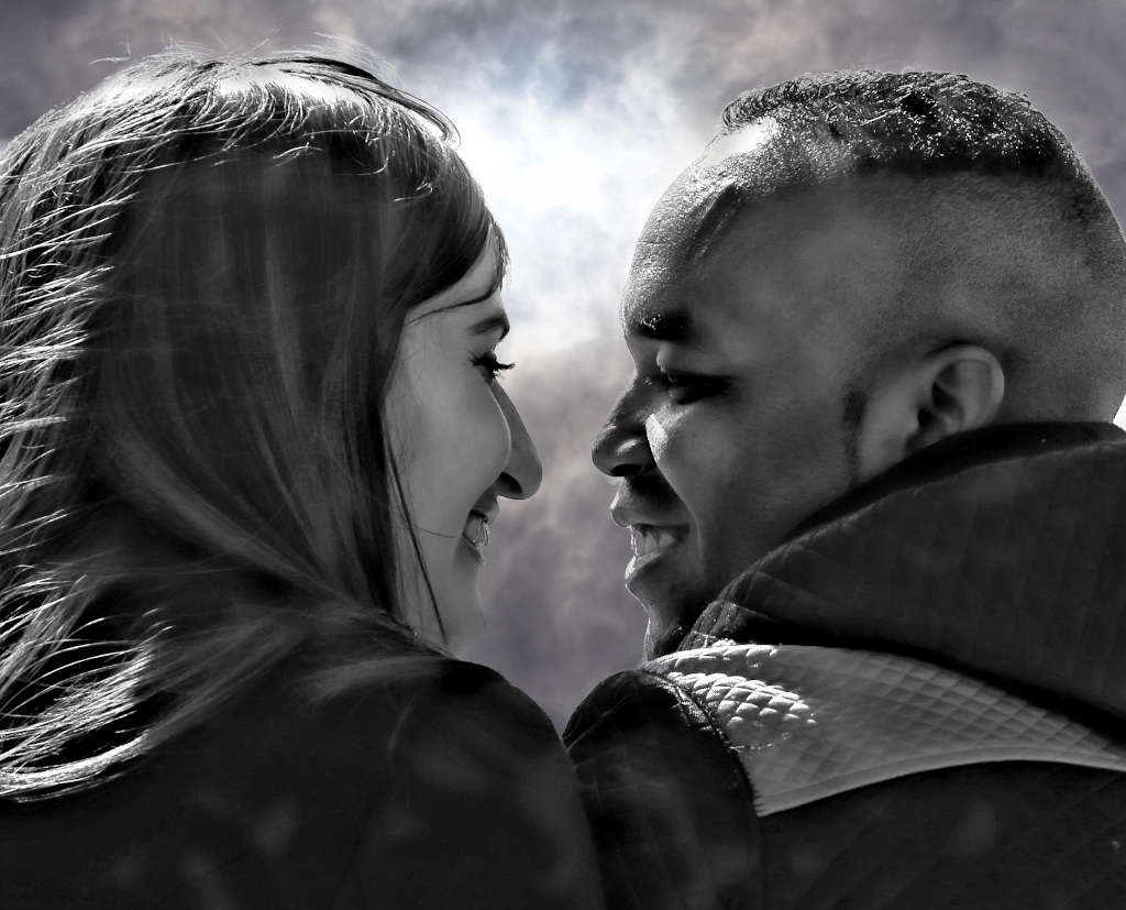 Photo noir et blance d'une femme et d'un homme se souriant de près.