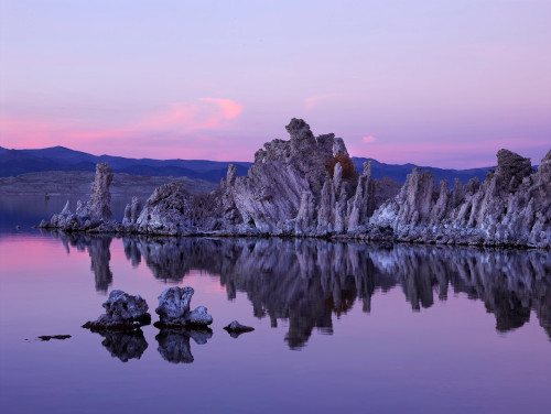 Coucher de soleil sur un massif rocheux dans un lac, aux couleurs de la fierté bisexuelle.