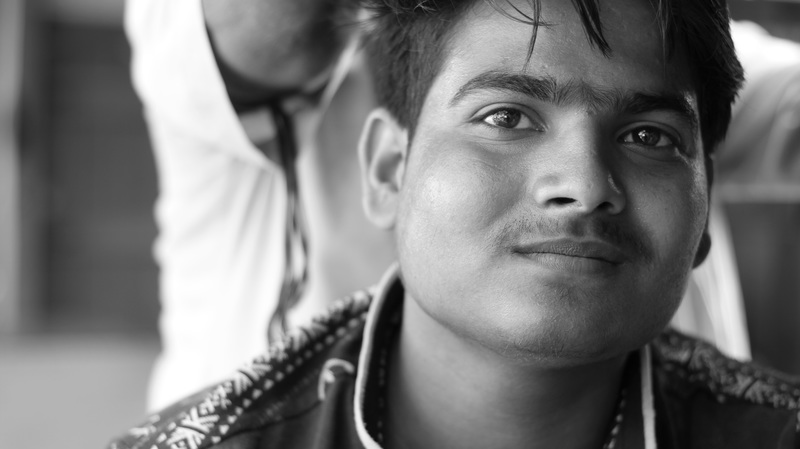 Photo noir et blanc d'un jeune homme souriant.